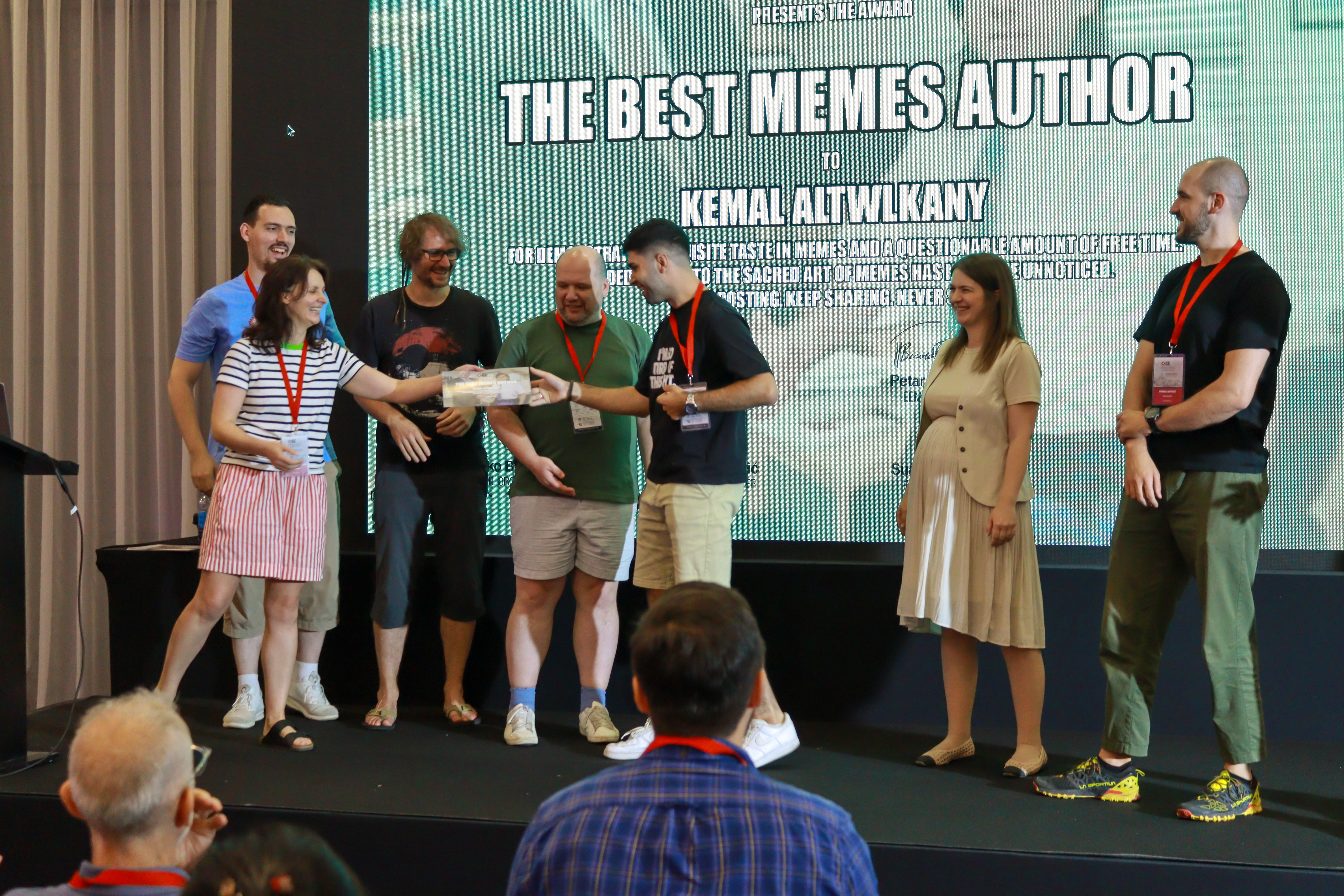 The organizing team awarding the best meme award.