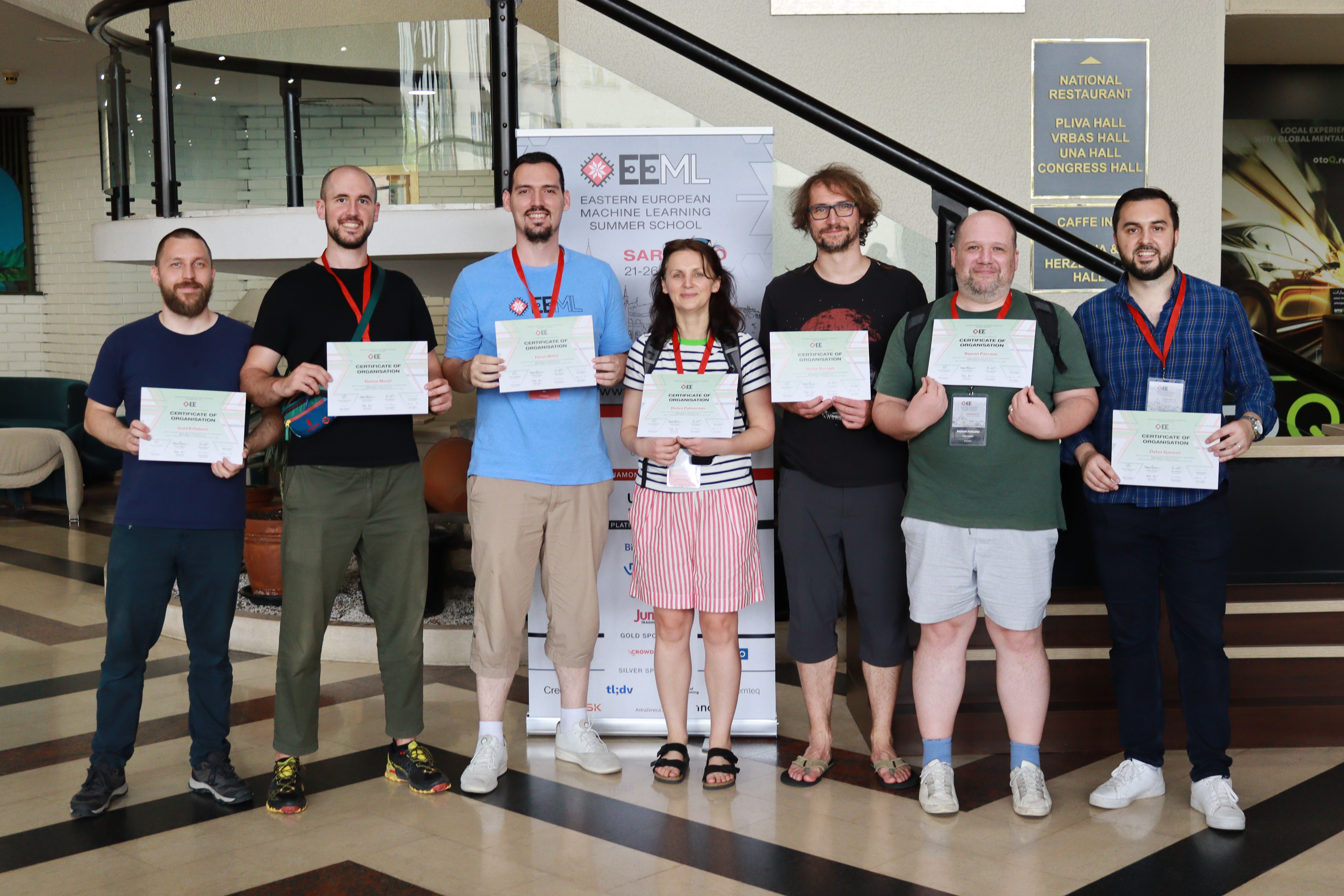 The main organizers smiling and holding their certificates of appreciation.